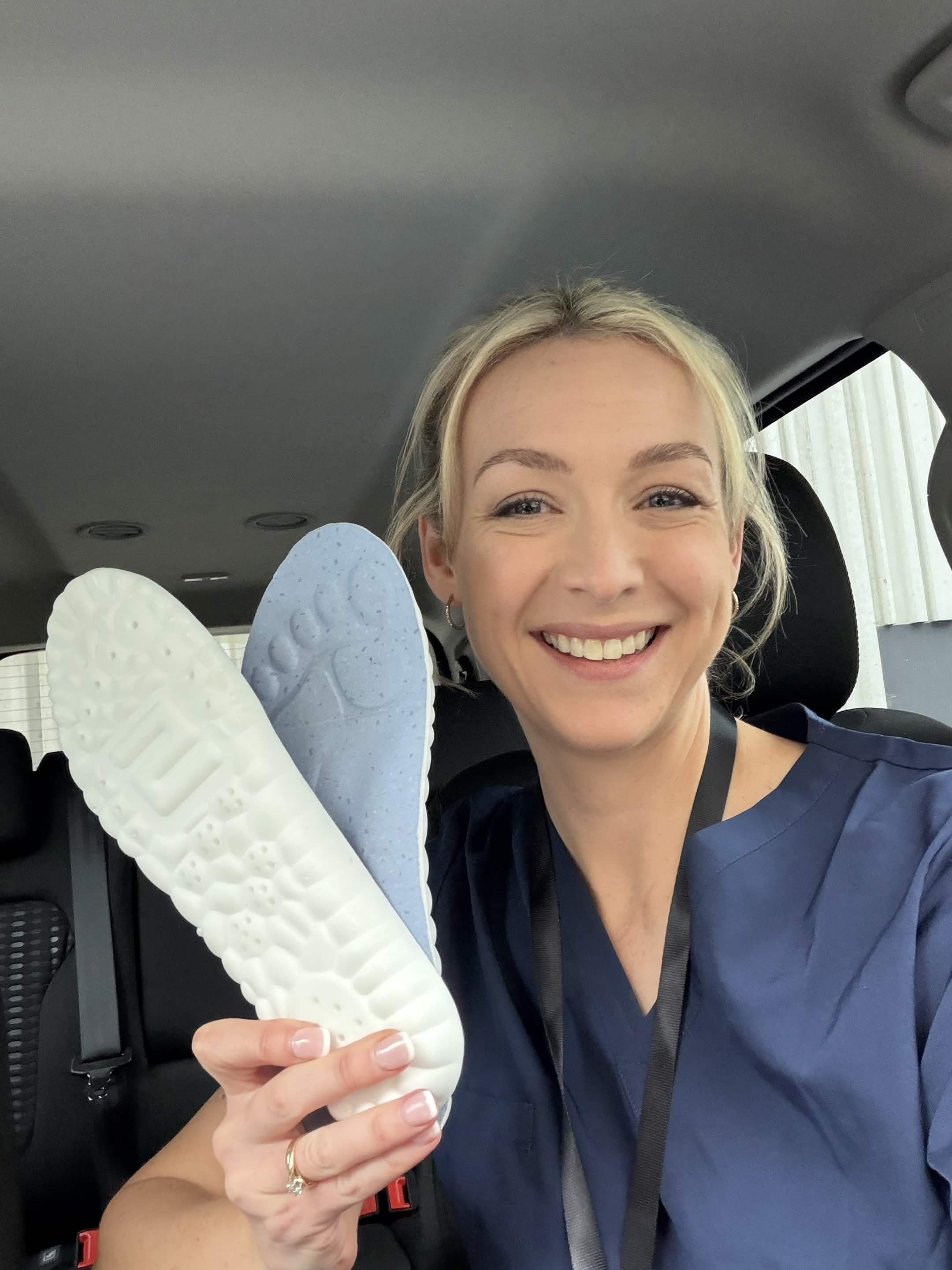 Worker holding a pair of WorkFit insoles