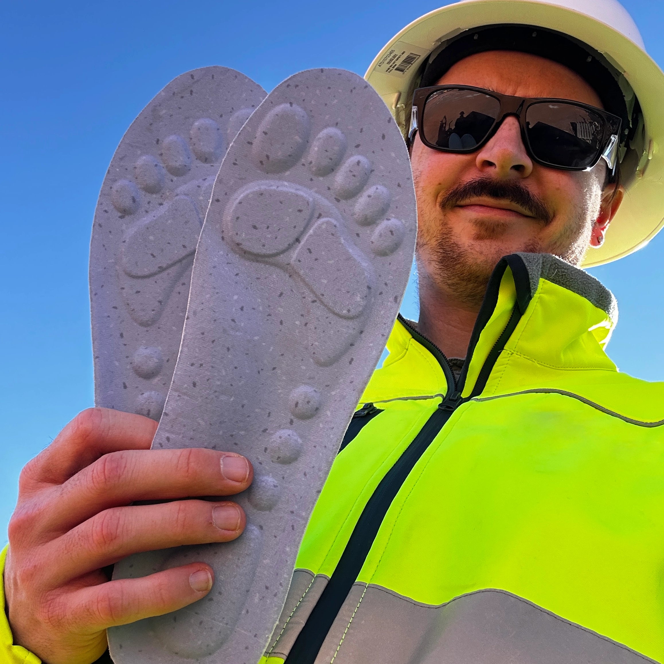 Worker holding WorkFit insoles on site