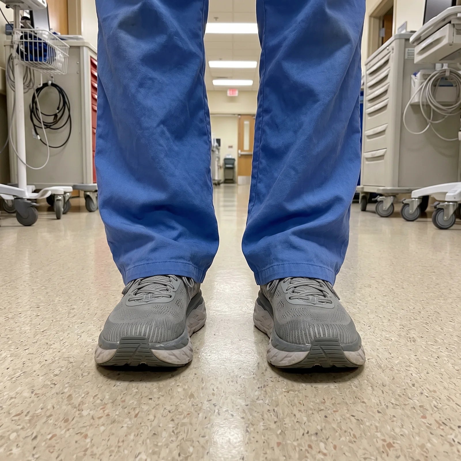 Nurse in scrubs standing in a hospital hallway after a long shift