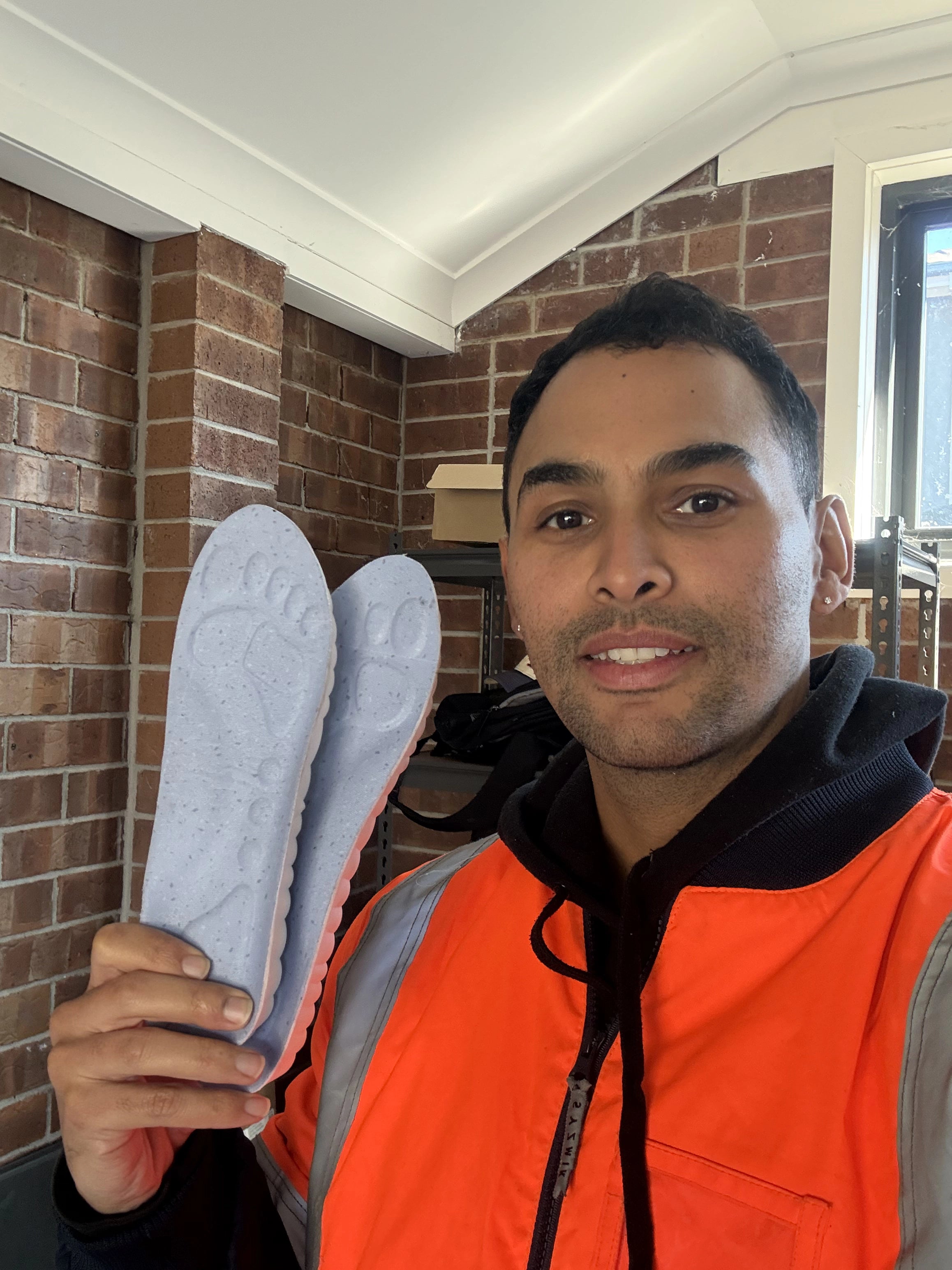 Worker holding a pair of WorkFit insoles