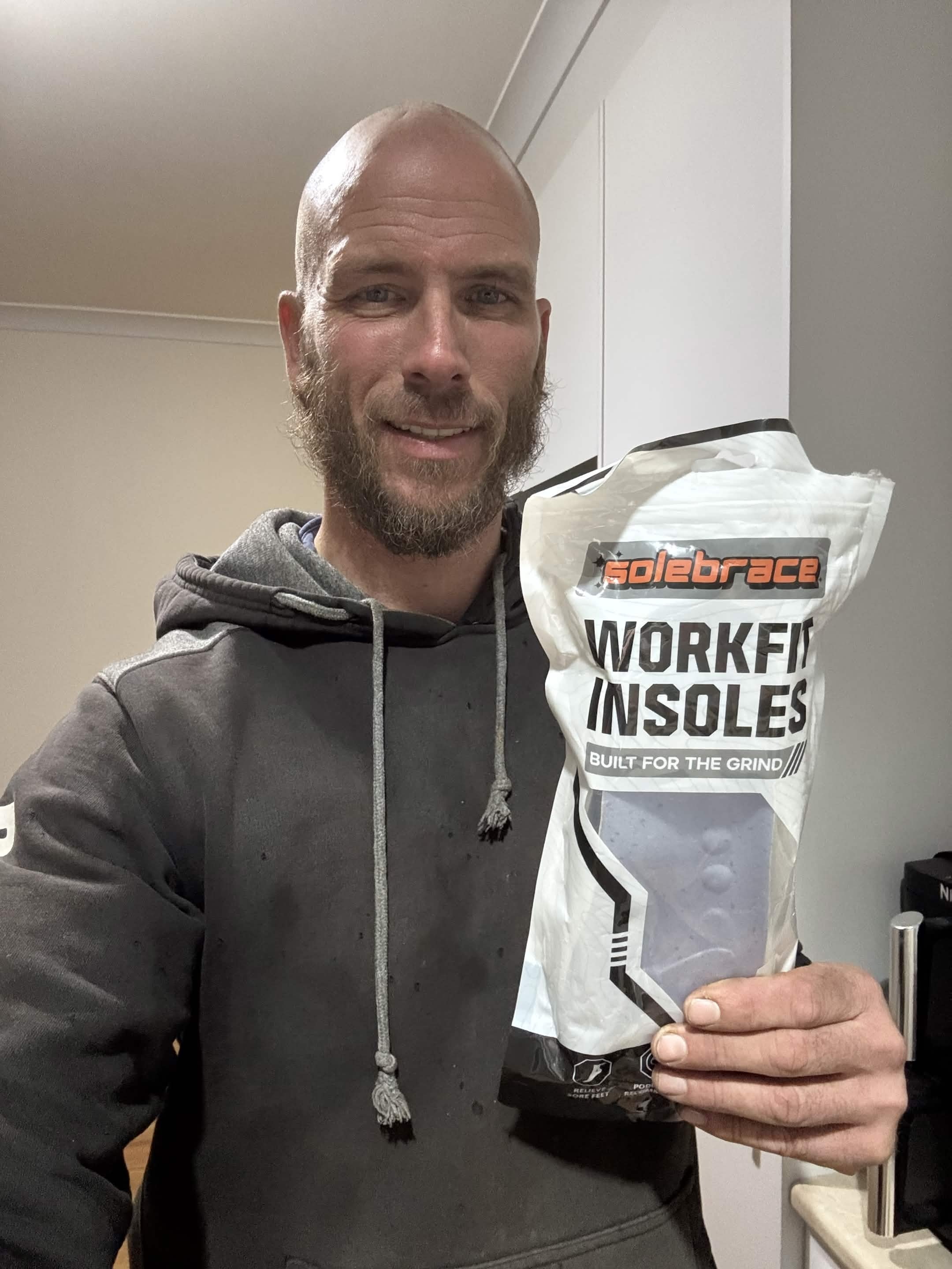 Worker holding a WorkFit Insoles pack indoors